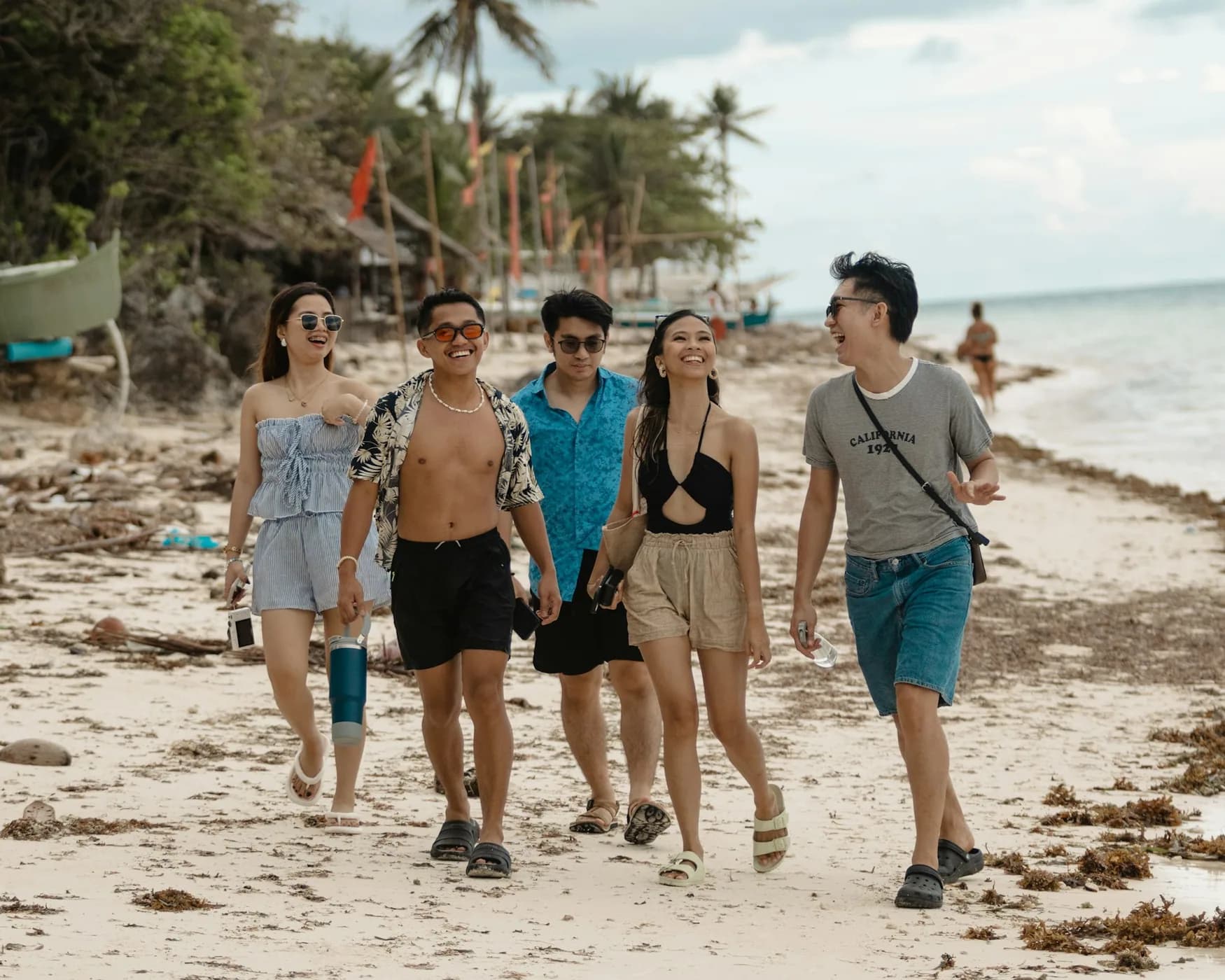 A group of friends walking and talking on a beach in Bohol