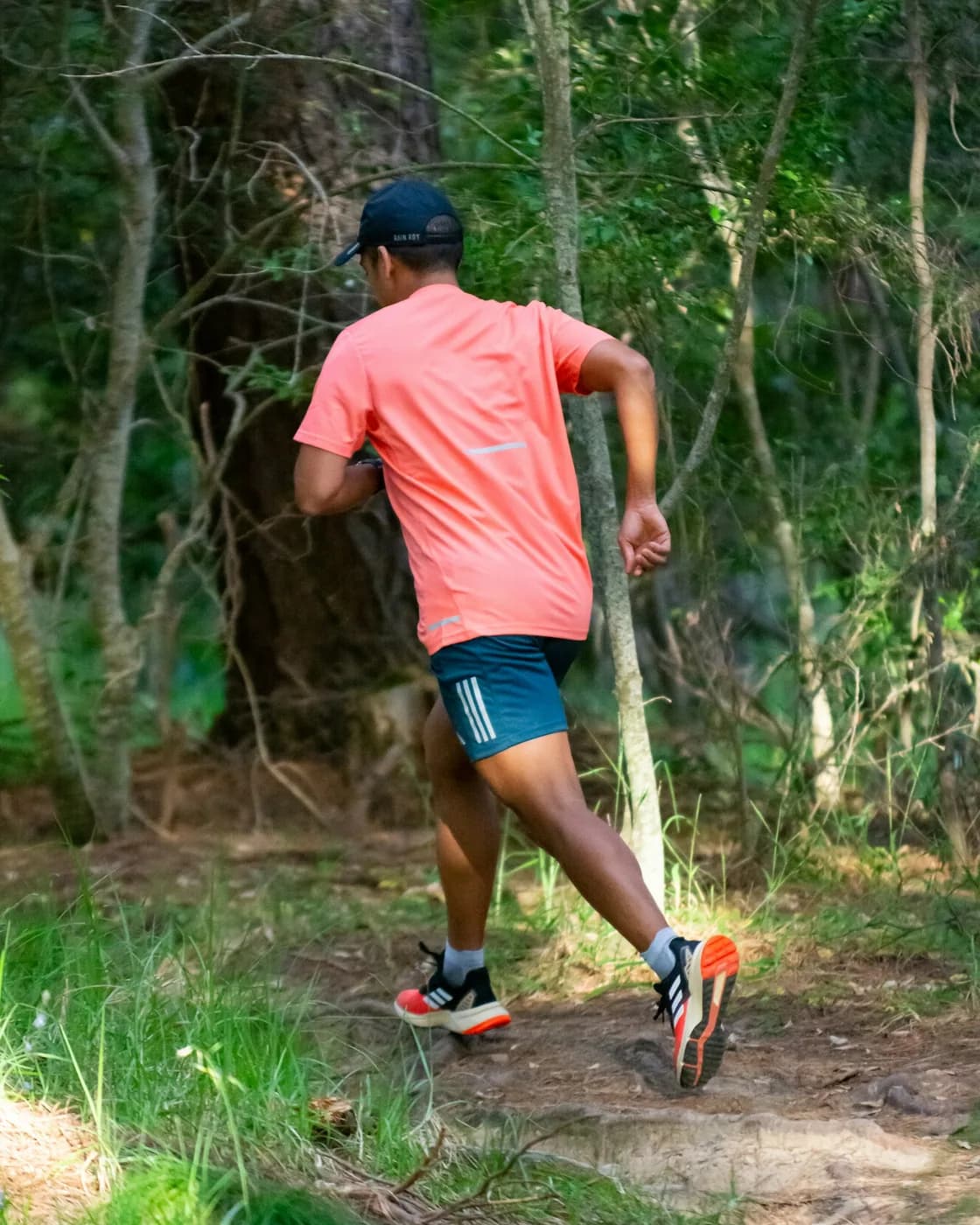 Trail runner moving quickly along a forest path
